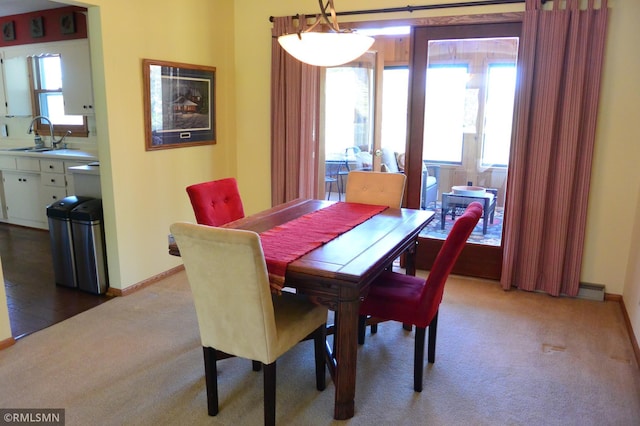 dining room with light colored carpet and baseboards