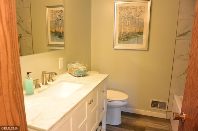 full bathroom with toilet, baseboards, visible vents, vanity, and wood finished floors