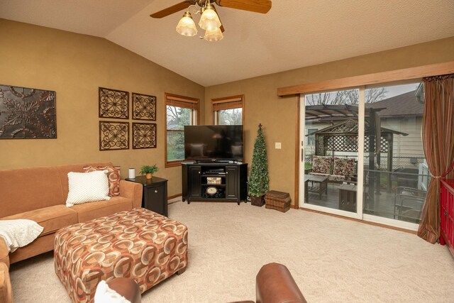 living area featuring baseboards, ceiling fan, light carpet, and vaulted ceiling