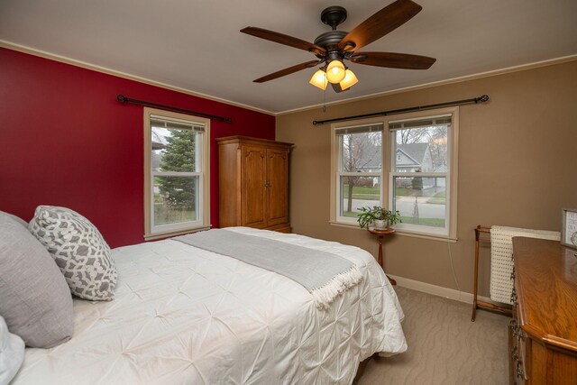 bedroom featuring crown molding, baseboards, light carpet, and ceiling fan