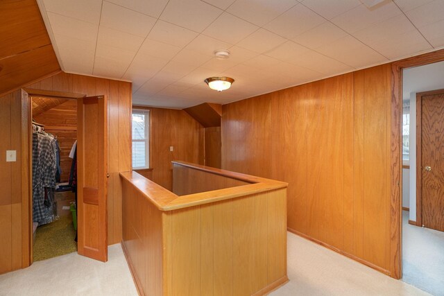 bar featuring wooden walls, light carpet, and lofted ceiling