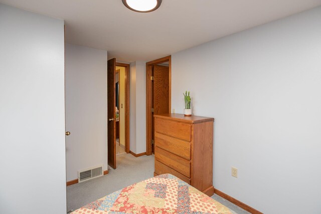 bedroom with visible vents, baseboards, and light colored carpet