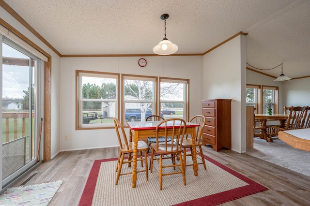 2765 Fraser St, La Prairie, MN 55744 - dining space with crown molding, visible vents, lofted ceiling, a textured ceiling, and light wood finished floors