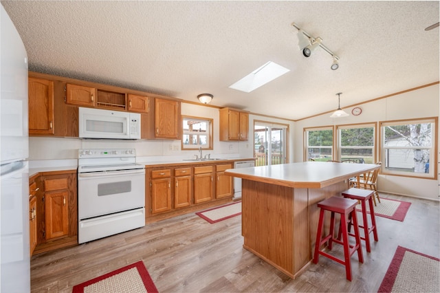 2765 Fraser St, La Prairie, MN 55744 - kitchen with light countertops, white appliances, a textured ceiling, and lofted ceiling with skylight