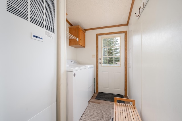 2765 Fraser St, La Prairie, MN 55744 - laundry room with a textured ceiling, cabinet space, a heating unit, ornamental molding, and washer and dryer