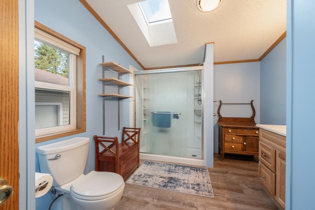 2765 Fraser St, La Prairie, MN 55744 - bathroom with crown molding, vaulted ceiling with skylight, toilet, a shower stall, and wood finished floors