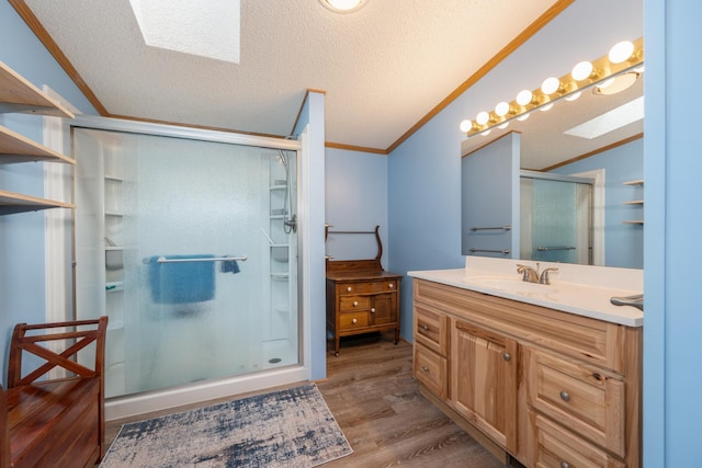 2765 Fraser St, La Prairie, MN 55744 - bathroom with vanity, ornamental molding, wood finished floors, a shower stall, and a skylight