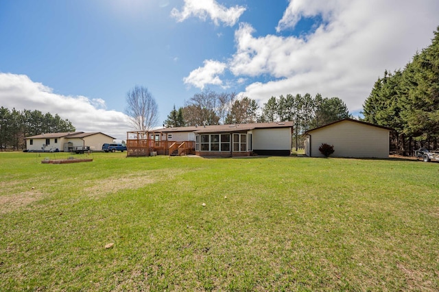2765 Fraser St, La Prairie, MN 55744 - rear view of house featuring a lawn, a wooden deck, and a sunroom