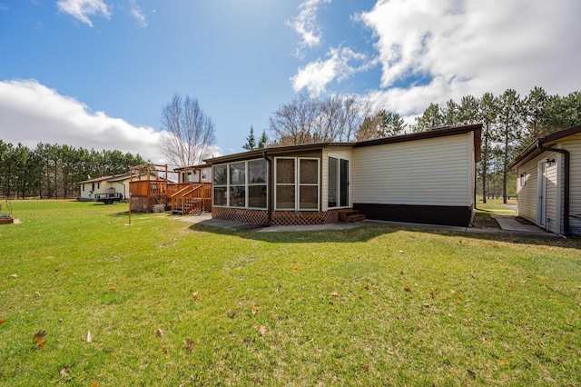 2765 Fraser St, La Prairie, MN 55744 - back of property featuring entry steps, a yard, a wooden deck, and a sunroom