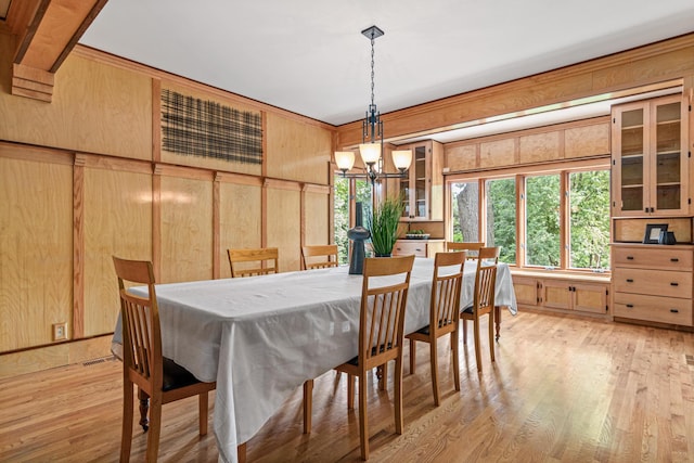 636 County Road B E, Maplewood, MN 55117 - dining area featuring a chandelier, light wood-style flooring, wood walls, and plenty of natural light