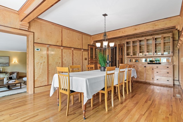 636 County Road B E, Maplewood, MN 55117 - dining room with a chandelier, wood walls, and light wood finished floors
