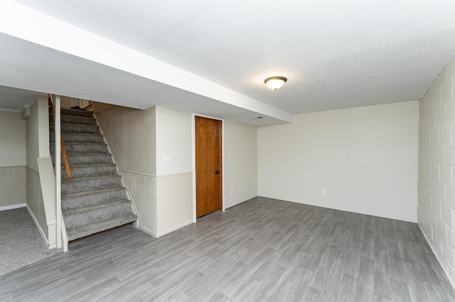 finished basement with stairs and wood finished floors