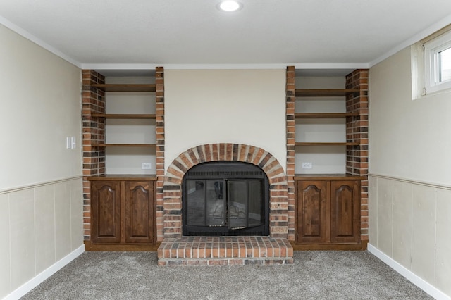 unfurnished living room featuring a wainscoted wall, a fireplace, and carpet flooring