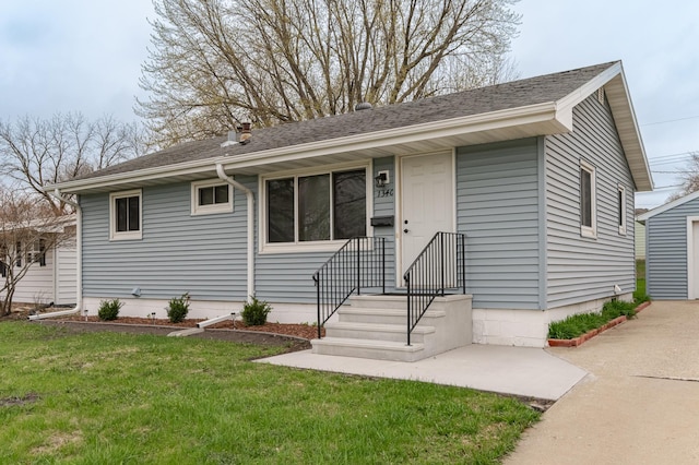 single story home with a shingled roof and a front lawn