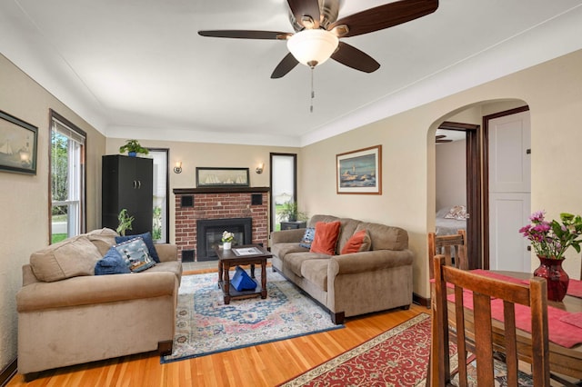 1100 Summit Ave, Saint Paul Park, MN 55071 - living area featuring light wood-style flooring, arched walkways, ceiling fan, and a brick fireplace