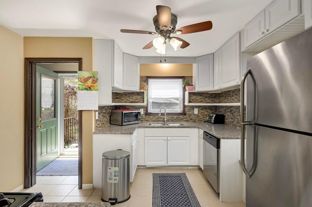 1100 Summit Ave, Saint Paul Park, MN 55071 - kitchen with stainless steel appliances, a sink, light tile patterned floors, decorative backsplash, and ceiling fan
