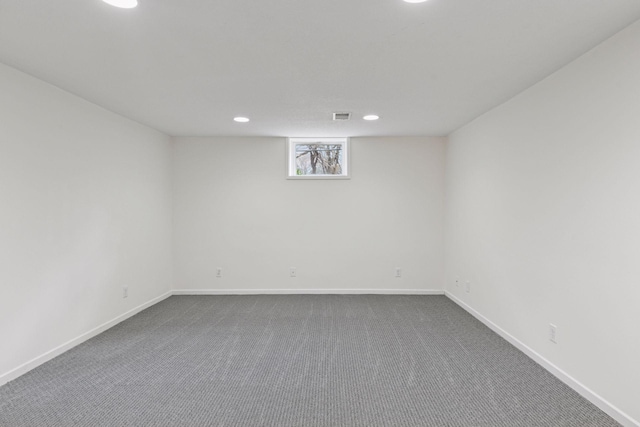 below grade area featuring recessed lighting, baseboards, visible vents, and dark colored carpet