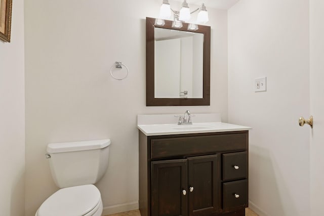 bathroom with vanity, baseboards, and toilet