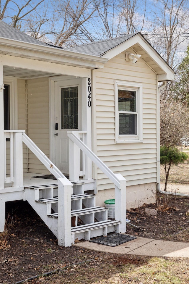 entrance to property with a shingled roof