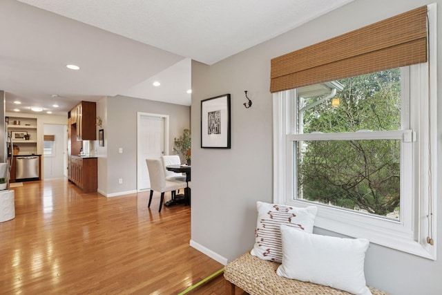 living area with recessed lighting, baseboards, and light wood finished floors