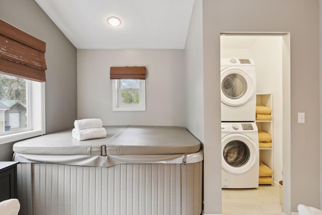 washroom with laundry area, stacked washer and dryer, and a wealth of natural light
