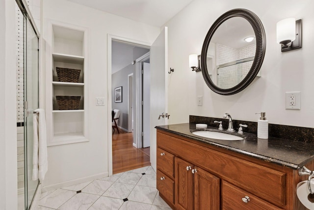 full bath featuring built in features, a stall shower, vanity, baseboards, and tile patterned floors