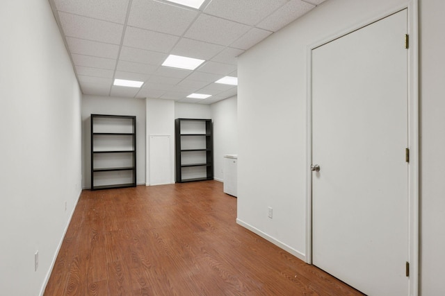 empty room with wood finished floors and a paneled ceiling