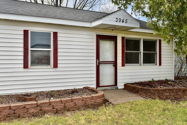 property entrance featuring roof with shingles