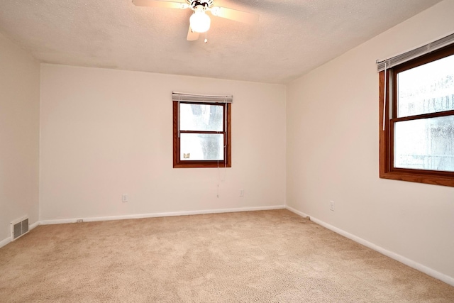 empty room featuring light colored carpet, baseboards, and visible vents