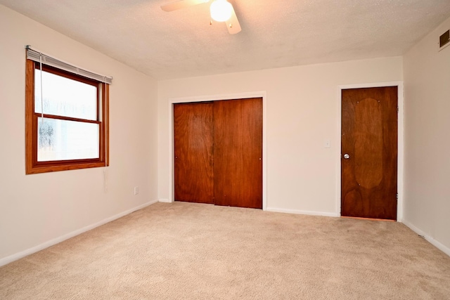 unfurnished bedroom featuring carpet flooring, baseboards, ceiling fan, and a closet