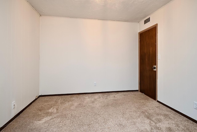 unfurnished room with carpet floors, a textured ceiling, and baseboards