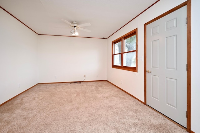 unfurnished room featuring baseboards, ceiling fan, light carpet, and ornamental molding