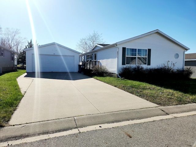 view of front of property featuring a garage, an outdoor structure, and a front lawn