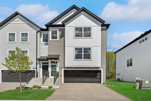 6645 Jody Ave S, Cottage Grove, MN 55016 - view of front of house with board and batten siding, a garage, asphalt driveway, and a front yard