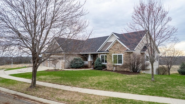 craftsman house featuring a front yard, driveway, and stone siding
