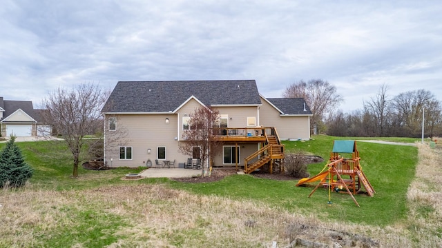 back of house with a wooden deck, a patio area, stairway, a playground, and a yard