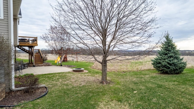 view of yard with stairs, an outdoor fire pit, a deck, and a patio