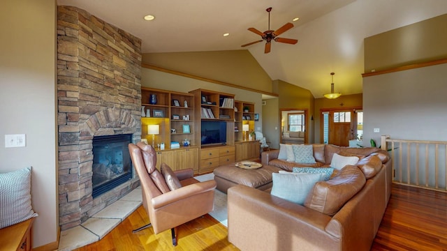 living room featuring ceiling fan, wood finished floors, a fireplace, and high vaulted ceiling