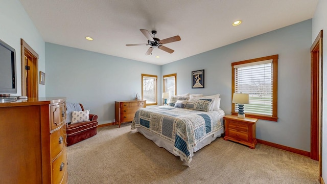 bedroom with baseboards, multiple windows, and light carpet