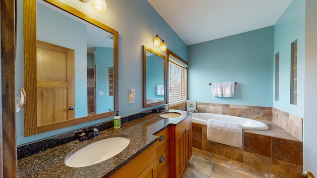 bathroom with a garden tub, a sink, and double vanity