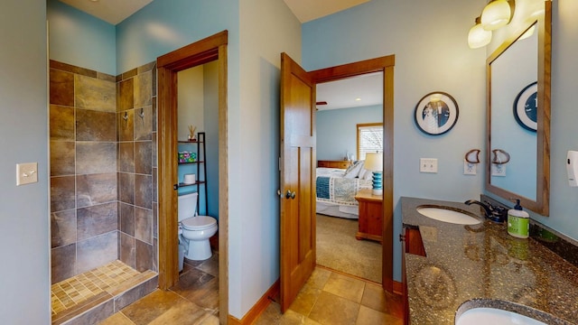 bathroom featuring tile patterned flooring, vanity, toilet, ensuite bathroom, and tiled shower