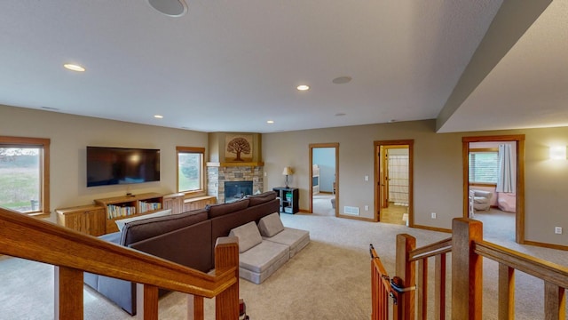 living room with recessed lighting, baseboards, light colored carpet, and a fireplace