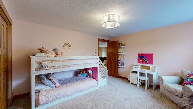 bedroom featuring carpet floors, a textured ceiling, and baseboards