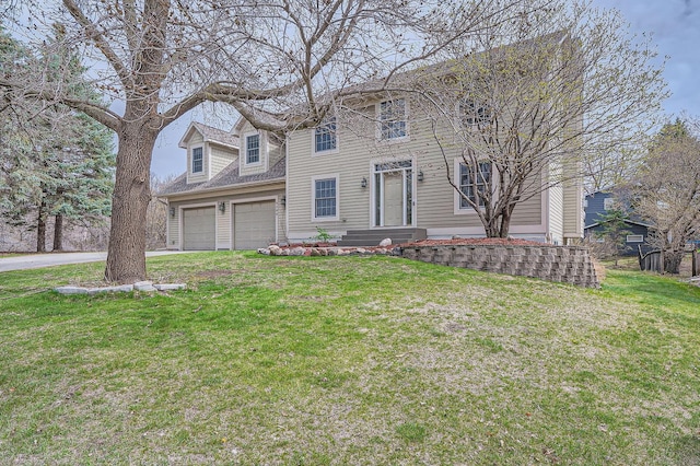 colonial-style house featuring a garage, a front lawn, and aphalt driveway