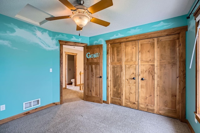 unfurnished bedroom featuring ceiling fan, visible vents, baseboards, a closet, and carpet flooring