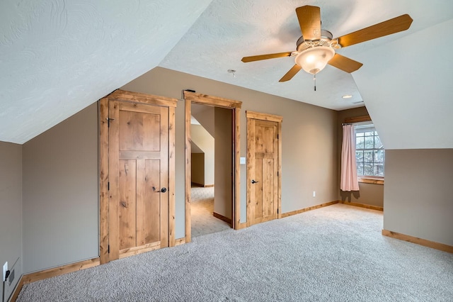 bonus room with baseboards, carpet floors, lofted ceiling, and ceiling fan