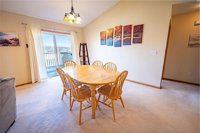 dining room featuring baseboards, light colored carpet, and lofted ceiling