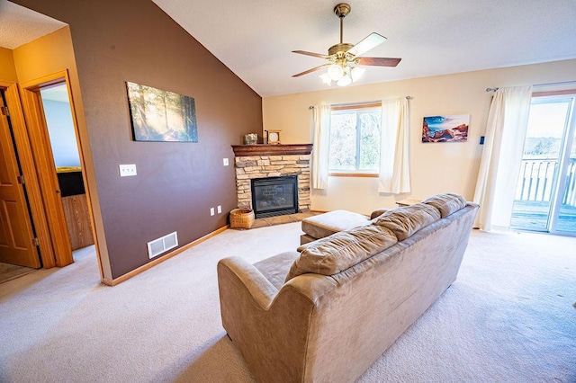 living room featuring ceiling fan, light colored carpet, a fireplace, vaulted ceiling, and visible vents