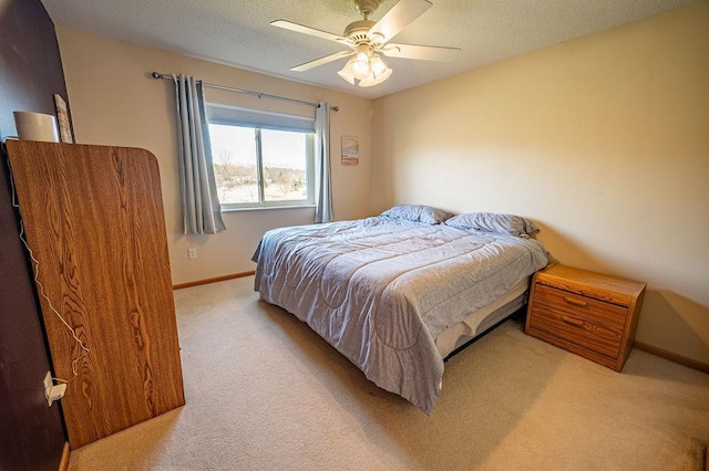 bedroom with baseboards, light carpet, a ceiling fan, and a textured ceiling