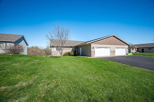 single story home featuring a garage, driveway, a front lawn, and stone siding